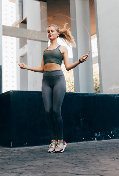 Blonde woman jumping the rope outdoors